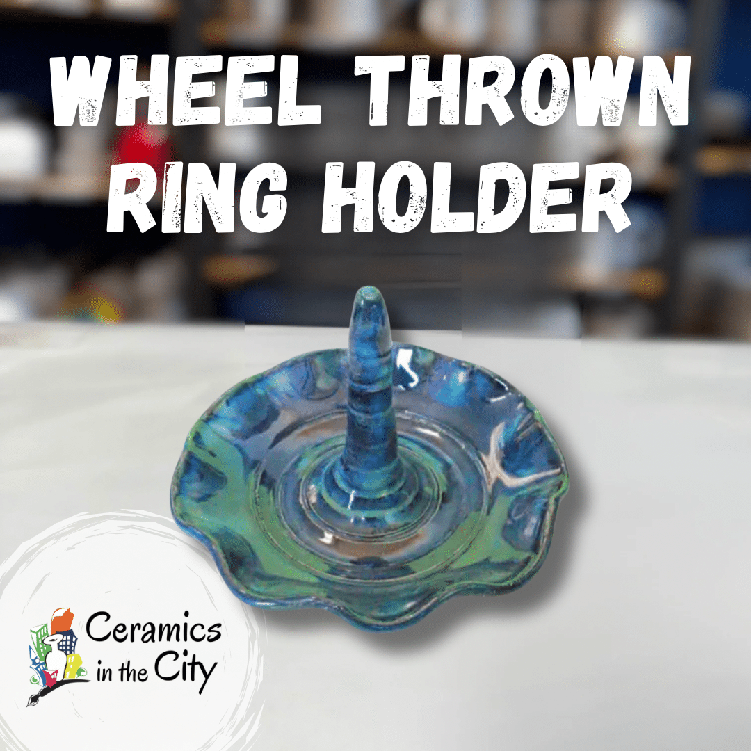 Handmade ceramic wheel-thrown ring holder with glossy blue-green glaze on pottery studio table